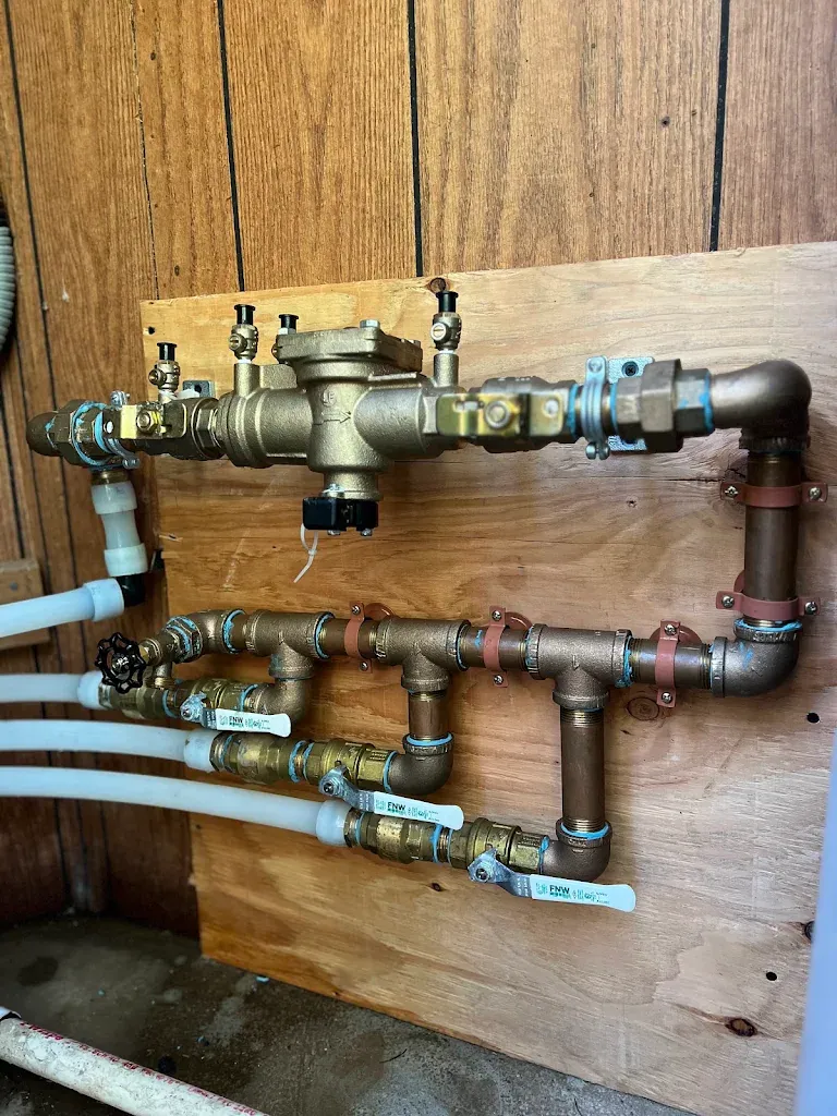 Brass backflow preventer assembly and irrigation manifold with ball valves mounted on plywood — Backflow Preventer Installation for Fox Island homes