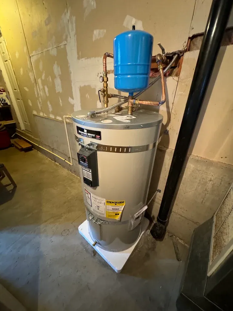 Bradford White water heater in a garage with blue expansion tank and copper piping