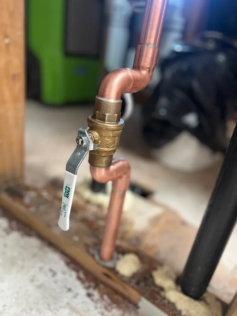 New brass ball valve soldered into a copper water main line in a crawlspace