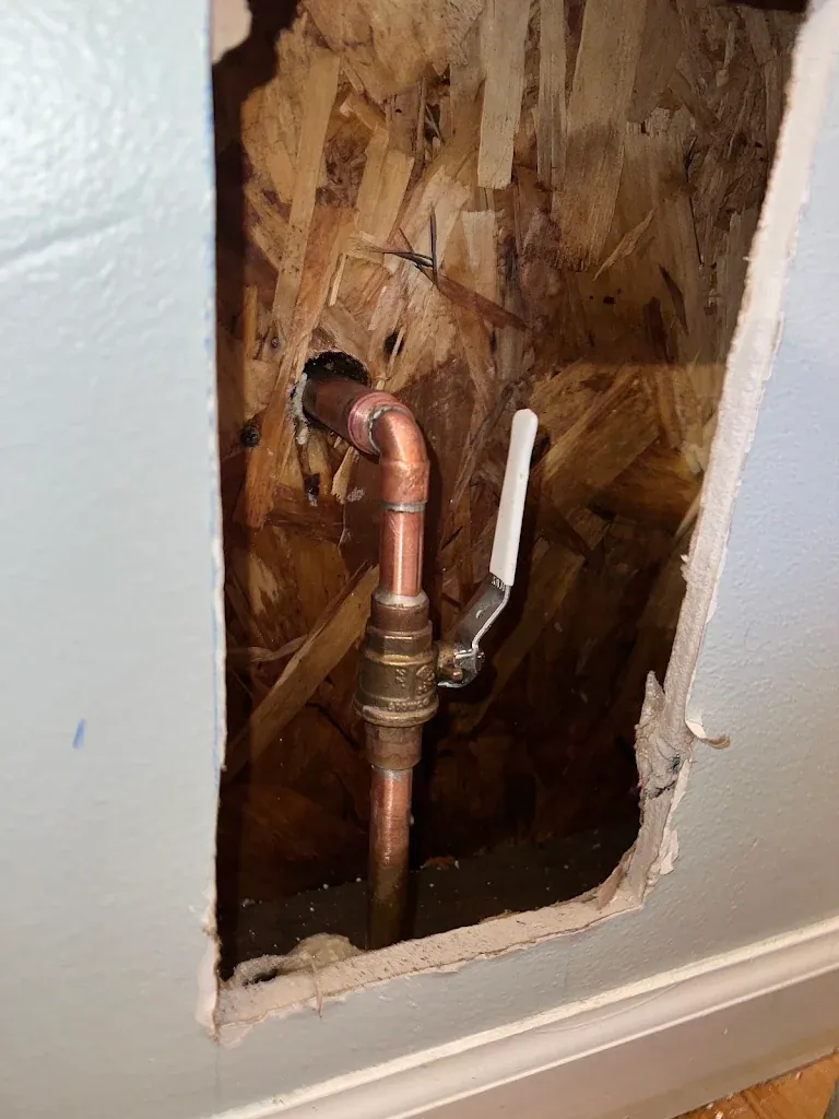 Copper pipe and new shutoff valve exposed in a cut-open section of drywall — Leak Detection & Repair for Allyn homes