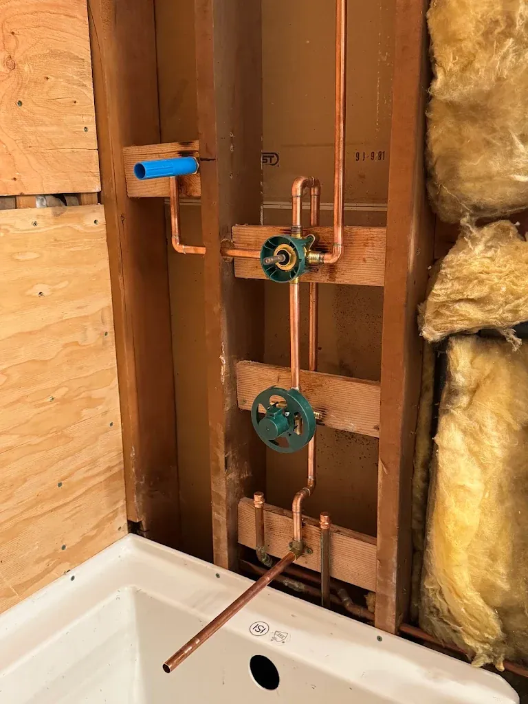 Copper rough-in for a tub and shower valve with capped stub-outs inside an open wall