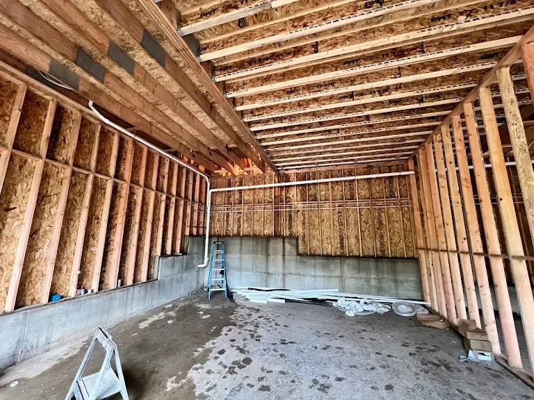 Framed garage with PVC drain and vent lines installed before drywall