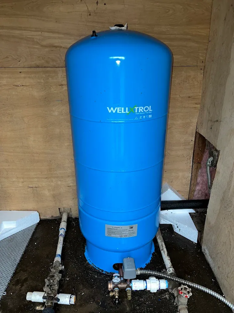 New blue Well-X-Trol well pressure tank installed in a pump house